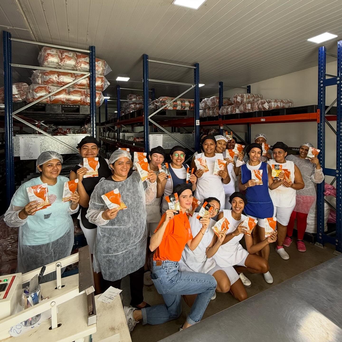 Equipe da Spirro em toucas e aventais segurando embalagens de produtos naturais no centro de produção em Fortaleza